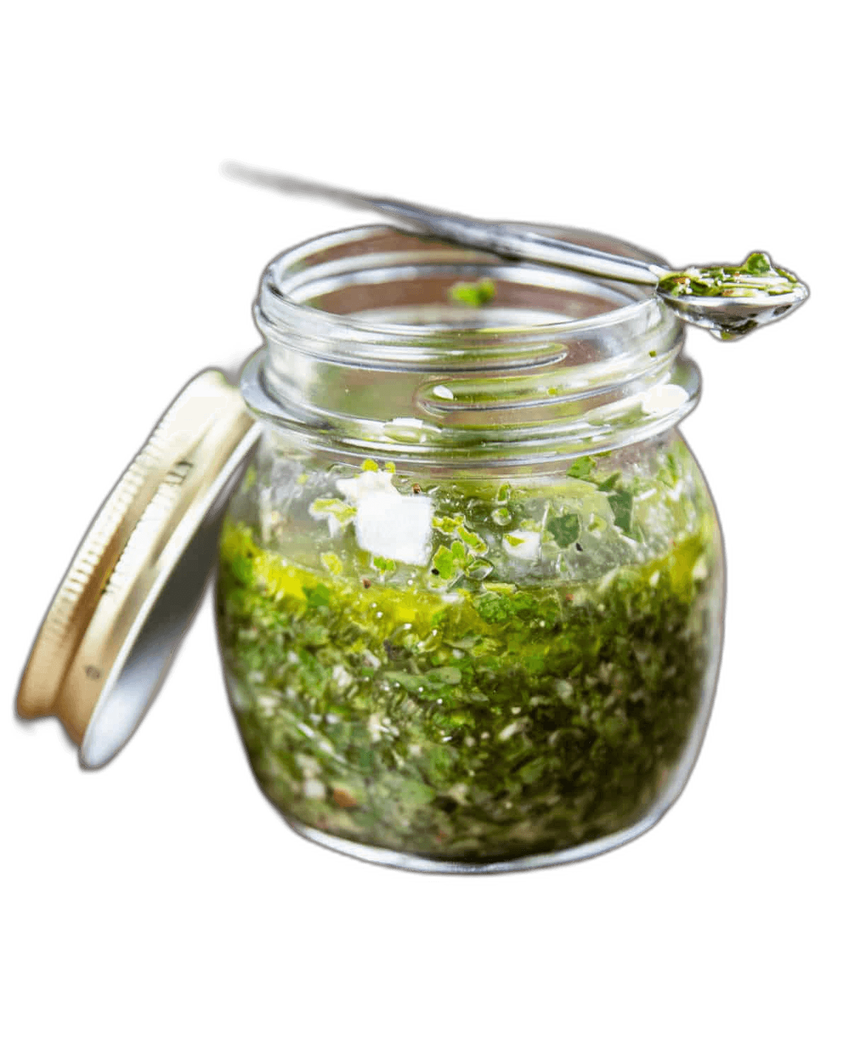 Marina's chimichurri in a glass jar with a spoon resting on top